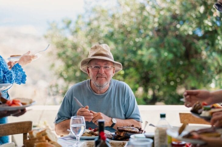 Lächelnder Senior auf Kreta beim Mittagessen