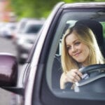 Blonde young girl driving in Crete