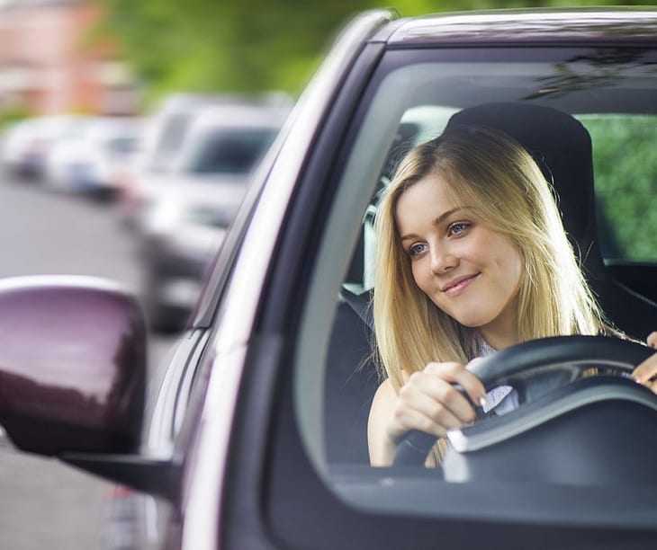 Blondes junges Mädchen beim Autofahren auf Kreta