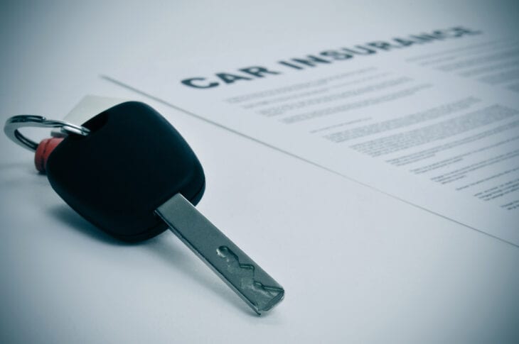 Car key on insurance policy contract