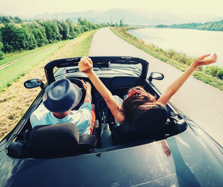 Een koppel rijdt in een cabriolet auto