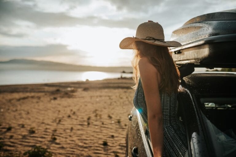 Fille avec un chapeau dans une voiture de location en Grèce