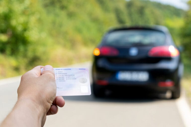 Tenant un permis de conduire près d'une location de voiture