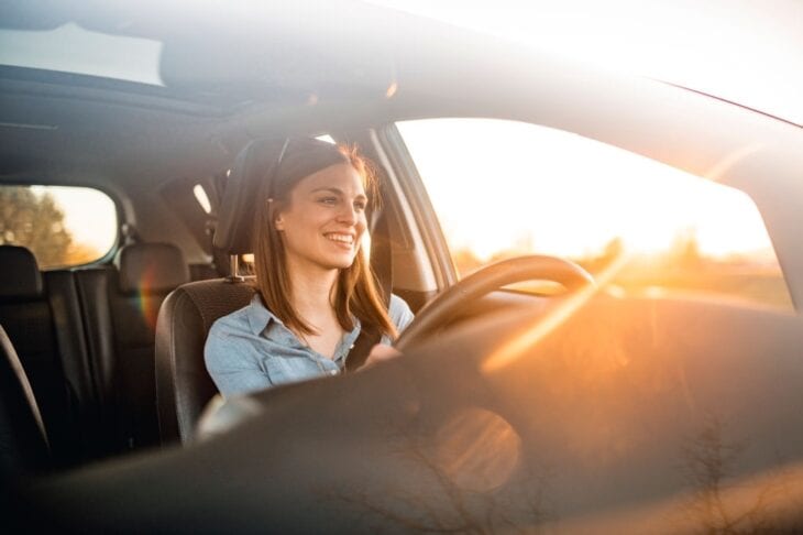 Een jong meisje rijdt in een huurauto