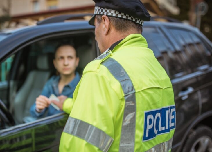 Polizist bei einer Verkehrskontrolle auf der Straße