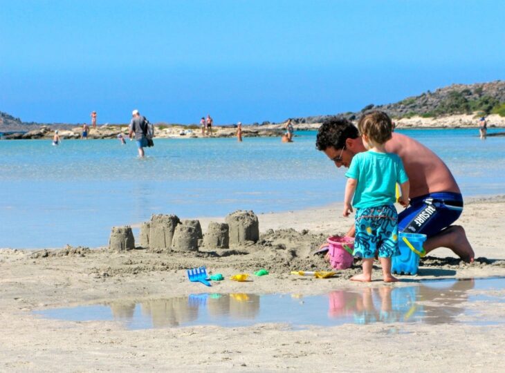 Baby und Papa spielen am Strand von Elafonissi