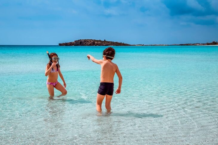 Een jongen en een meisje babbelen terwijl ze zich klaarmaken om te gaan snorkelen op Kreta