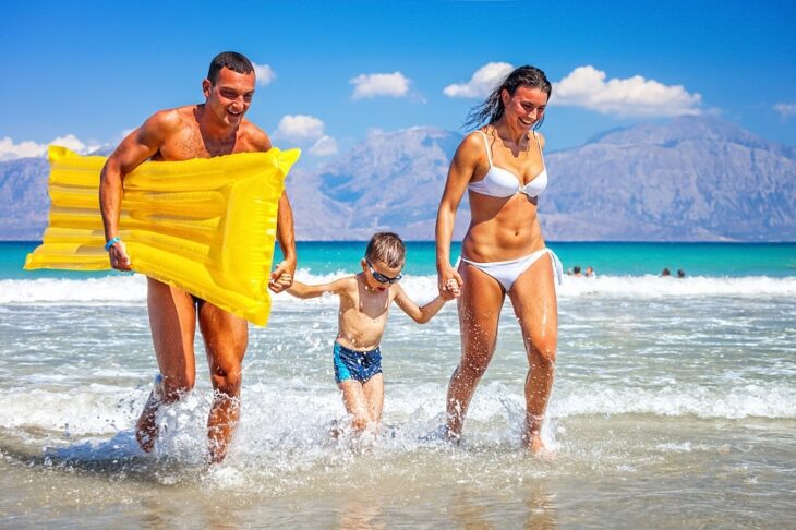 Gelukkig gezin dat plezier maakt op het strand van Kreta